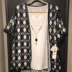 White sleeveless tank with gold-tone necklace. White and Black Jacket attached.
